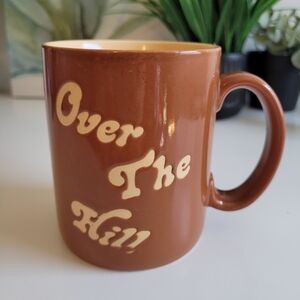 Vintage Russ Brown Ceramic Mug with Cream Text Over The Hill